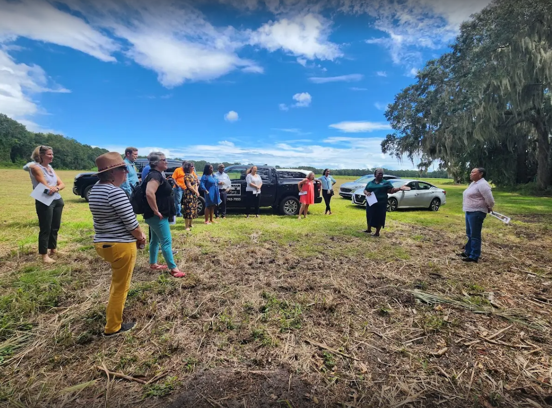 Landowners gathered in a field for a Center for Heirs' Property outdoor education event