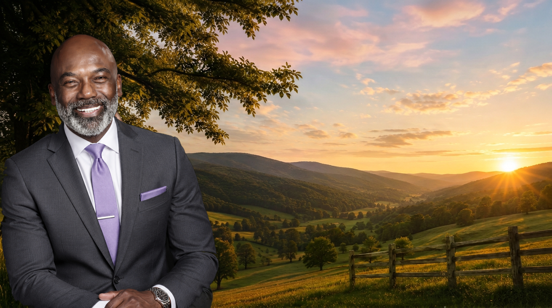 Sean T. Morris seated at a rustic fence overlooking a golden-hour mountain valley
